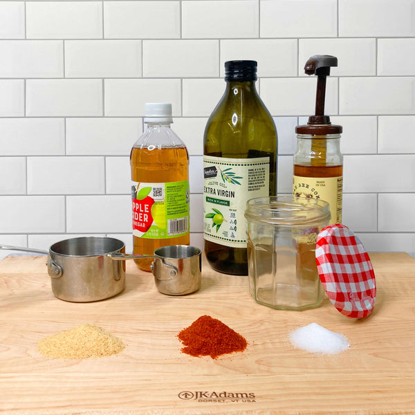 Ingredients for Apple Cider Honey Vinaigrette on a JK Adams Cutting board.