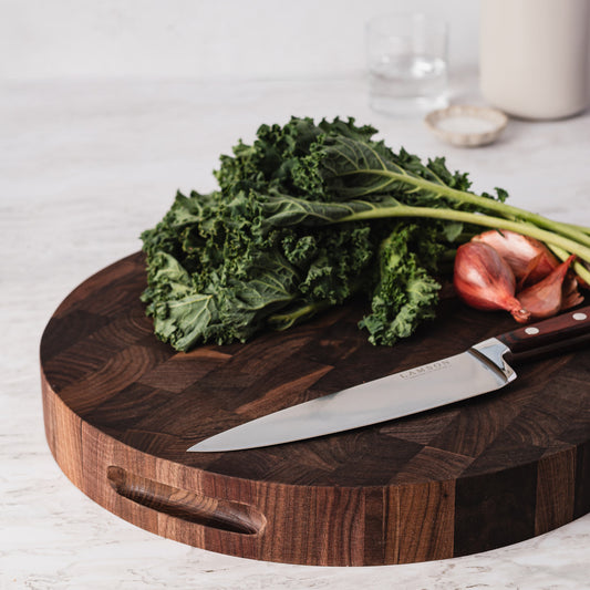 JK Adams Pro 12" Roun Walnut Cutting board with kale, shallots and an 8" Lamson Chef Knife.
